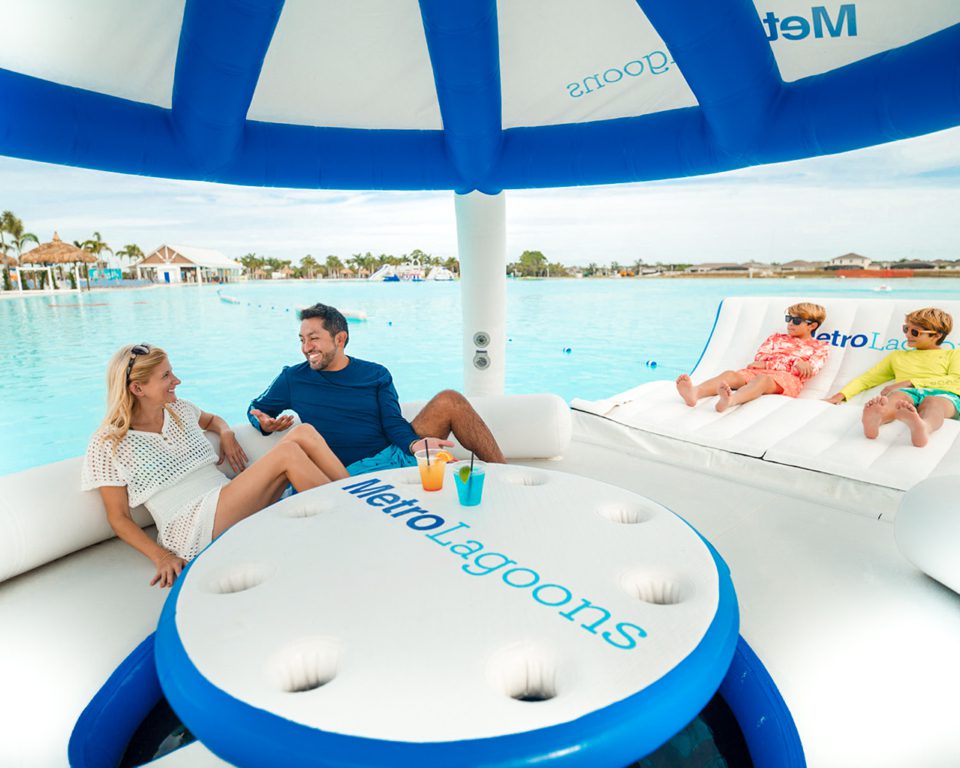 Family lounging on inflatable cabana in the blue lagoon.